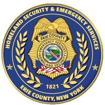 Yellow badge with County Seal in middle - blue circle with workding Homeland Security & Emergency Services, Erie County NY