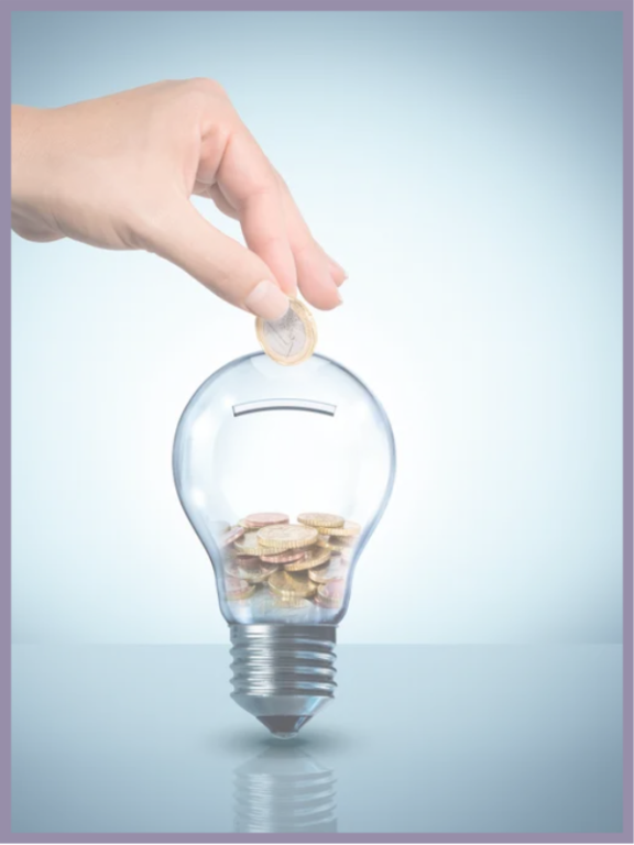 A hand dropping a coin into a light bulb like a piggy bank.