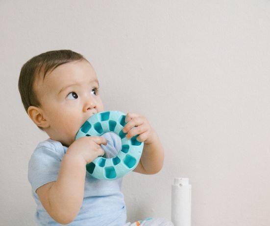 Infant putting toy in mouth