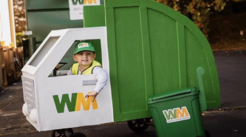 A toddler in a home made garbage/recycling truck costume